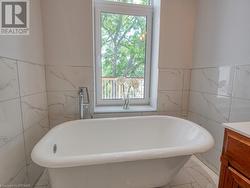 Bathroom with vanity, tile walls, and a tub - 