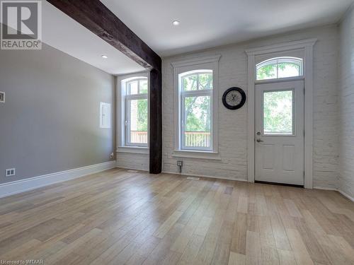 Foyer featuring light wood-type flooring, a healthy amount of sunlight, and brick wall - 151 Thames Street S, Ingersoll, ON 