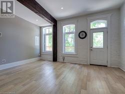 Foyer featuring light wood-type flooring, a healthy amount of sunlight, and brick wall - 