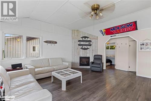 Living room featuring a large fireplace, dark hardwood / wood-style flooring, lofted ceiling, and ceiling fan - 68 Wolverine Beach Rd, Port Severn, ON - Indoor Photo Showing Living Room With Fireplace