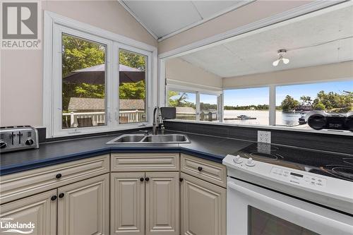 Kitchen featuring a wealth of natural light, lofted ceiling, sink, and white range with electric cooktop - 68 Wolverine Beach Rd, Port Severn, ON - Indoor Photo Showing Kitchen With Double Sink