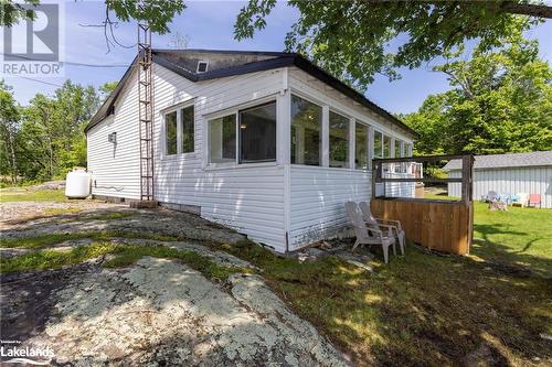 View of home's exterior with a sunroom and a yard - 68 Wolverine Beach Rd, Port Severn, ON - Outdoor