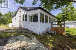 View of home's exterior with a sunroom and a yard - 