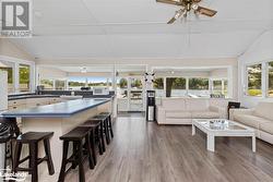 Sunroom / solarium featuring ceiling fan, plenty of natural light, and vaulted ceiling - 