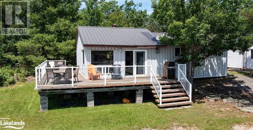 Rear view of property featuring a deck and a lawn - 64 Wolverine Beach Road, Port Severn, ON - Outdoor With Deck Patio Veranda