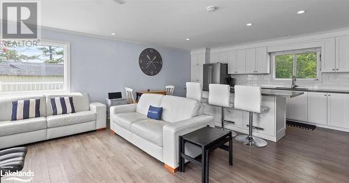 Living room featuring plenty of natural light, sink, crown molding, and light hardwood / wood-style flooring - 64 Wolverine Beach Road, Port Severn, ON - Indoor