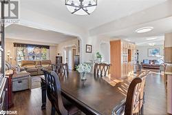 Dining room with dark wood-type flooring and a notable chandelier - 