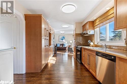 Kitchen featuring stainless steel appliances, dark hardwood / wood-style floors, sink, and backsplash - 2604 Homelands Drive, Mississauga, ON - Indoor Photo Showing Kitchen