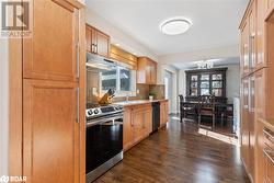 Kitchen with stainless steel electric range, backsplash, black dishwasher, dark hardwood / wood-style flooring, and sink - 