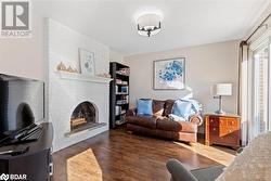 Living room with a fireplace and dark wood-type flooring - 