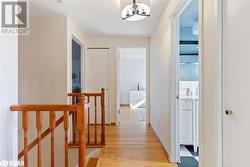 Corridor featuring an inviting chandelier and light hardwood / wood-style flooring - 