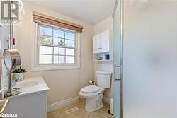 Bathroom featuring tile patterned flooring, vanity, toilet, and an enclosed shower - 