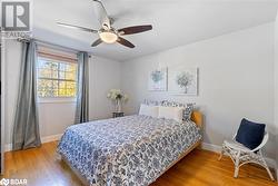 Bedroom with ceiling fan and wood-type flooring - 