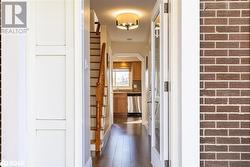 Corridor featuring dark wood-type flooring and brick wall - 