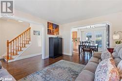 Living room featuring dark hardwood / wood-style floors, an inviting chandelier, and french doors - 