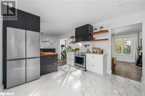 Kitchen with butcher block counters, light hardwood / wood-style flooring, tasteful backsplash, white cabinetry, and appliances with stainless steel finishes - 18133 Loyalist Parkway, Prince Edward County, ON - Indoor Photo Showing Kitchen