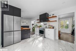 Kitchen with butcher block counters, light hardwood / wood-style flooring, tasteful backsplash, white cabinetry, and appliances with stainless steel finishes - 