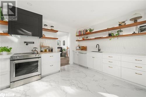 Kitchen with white dishwasher, sink, tasteful backsplash, white cabinetry, and stainless steel electric range oven - 18133 Loyalist Parkway, Prince Edward County, ON - Indoor Photo Showing Kitchen