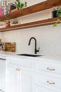 Details featuring dishwasher, tasteful backsplash, white cabinetry, and sink - 