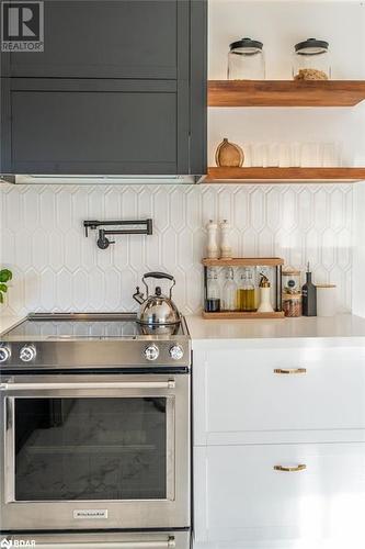 Kitchen with decorative backsplash and stainless steel range with electric stovetop - 18133 Loyalist Parkway, Prince Edward County, ON - Indoor Photo Showing Kitchen