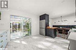 Kitchen with wooden counters, hanging light fixtures, and stainless steel fridge - 