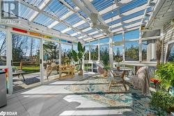 Unfurnished sunroom featuring ceiling fan and vaulted ceiling - 