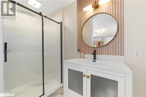 Bathroom featuring vanity, wooden walls, and a shower with door - 18133 Loyalist Parkway, Prince Edward County, ON - Indoor Photo Showing Bathroom