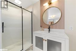 Bathroom featuring vanity, wooden walls, and a shower with door - 