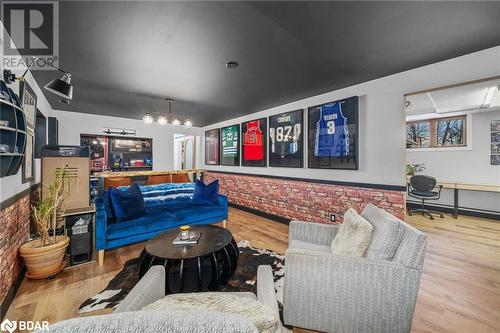 Living room with wood-type flooring, built in desk, and brick wall - 18133 Loyalist Parkway, Prince Edward County, ON - Indoor