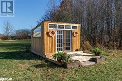 View of outdoor structure featuring a lawn - 