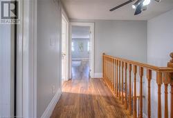 Hallway with a textured ceiling and dark hardwood / wood-style flooring - 