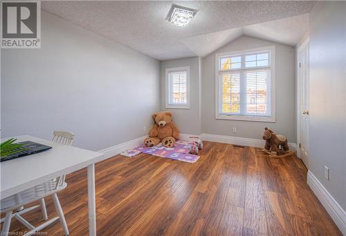 Miscellaneous room with dark hardwood / wood-style flooring, a textured ceiling, and vaulted ceiling - 83 Bridlewreath Street, Kitchener, ON - Indoor Photo Showing Bedroom