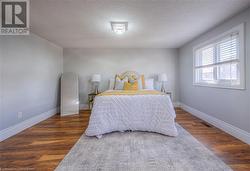 Bedroom with dark wood-type flooring and a textured ceiling - 