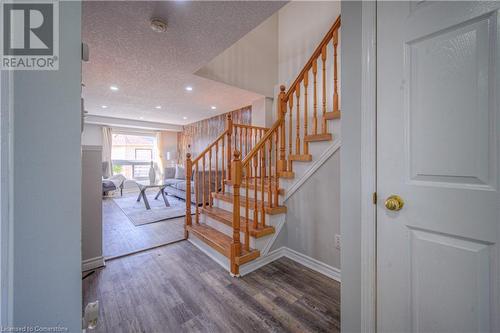 Staircase featuring wood-type flooring and a textured ceiling - 83 Bridlewreath Street, Kitchener, ON - Indoor Photo Showing Other Room