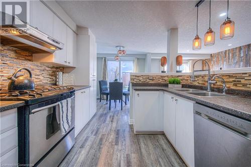 Kitchen featuring white cabinets, stainless steel appliances, a textured ceiling, and sink - 83 Bridlewreath Street, Kitchener, ON - Indoor Photo Showing Kitchen With Double Sink