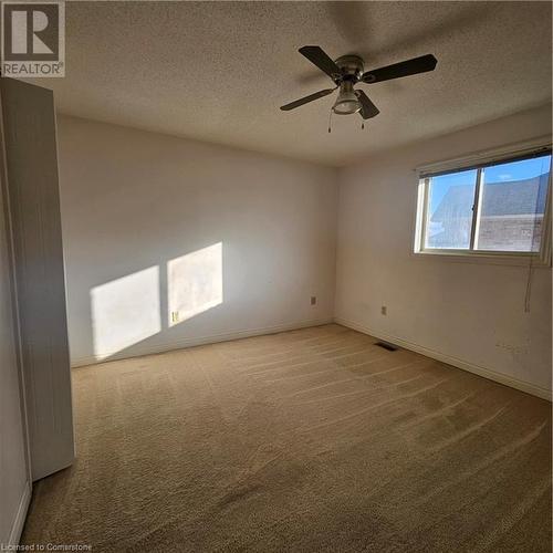 Carpeted spare room with a textured ceiling and ceiling fan - 115 Cranston Avenue, Cambridge, ON - Indoor Photo Showing Other Room