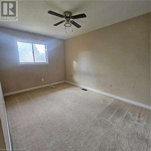 Carpeted empty room featuring a textured ceiling and ceiling fan - 115 Cranston Avenue, Cambridge, ON - Indoor Photo Showing Other Room