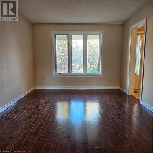 Unfurnished room with dark hardwood / wood-style floors and a textured ceiling - 115 Cranston Avenue, Cambridge, ON - Indoor Photo Showing Other Room