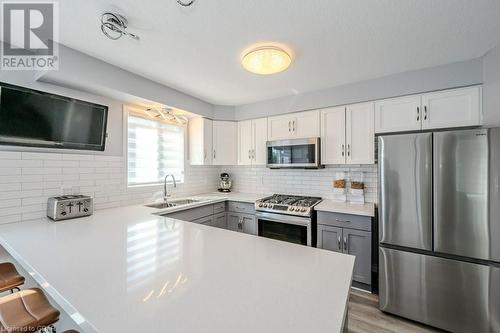 Kitchen with stainless steel appliances, gray cabinetry, sink, and white cabinets - 192 Severn Drive, Guelph, ON - Indoor Photo Showing Kitchen With Upgraded Kitchen