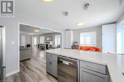 Kitchen with stainless steel appliances, gray cabinets, and light hardwood / wood-style flooring - 