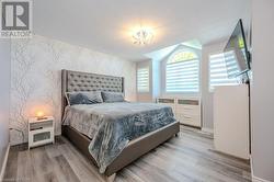 Bedroom with a textured ceiling and light hardwood / wood-style floors - 