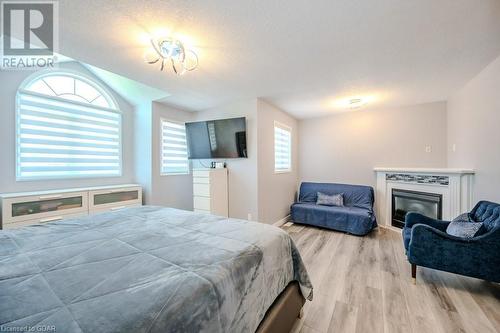 Bedroom with light wood-type flooring and a textured ceiling - 192 Severn Drive, Guelph, ON - Indoor Photo Showing Bedroom With Fireplace