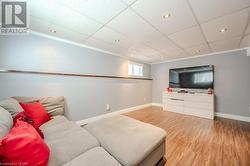 Living room featuring a drop ceiling, wood-type flooring, and crown molding - 