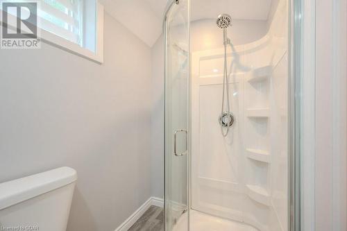 Bathroom featuring lofted ceiling, hardwood / wood-style flooring, toilet, and a shower with shower door - 192 Severn Drive, Guelph, ON - Indoor Photo Showing Bathroom