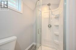 Bathroom featuring lofted ceiling, hardwood / wood-style flooring, toilet, and a shower with shower door - 