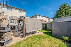 View of yard with a wooden deck, a storage shed, and a patio area - 