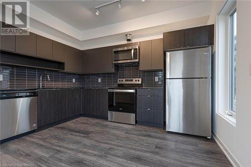 Kitchen featuring stainless steel appliances, a healthy amount of sunlight, decorative backsplash, and dark hardwood / wood-style flooring - 1095 Cooke Boulevard Unit# 42, Burlington, ON - Indoor Photo Showing Kitchen With Stainless Steel Kitchen