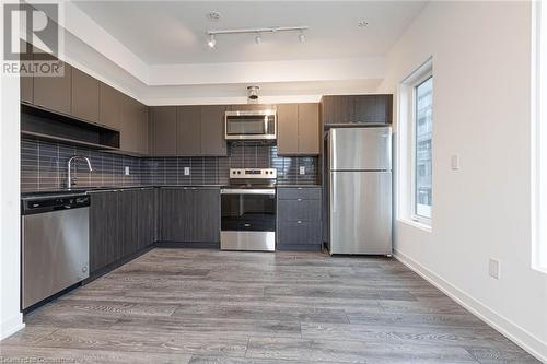 Kitchen featuring a wealth of natural light, appliances with stainless steel finishes, and light hardwood / wood-style flooring - 1095 Cooke Boulevard Unit# 42, Burlington, ON - Indoor Photo Showing Kitchen With Stainless Steel Kitchen