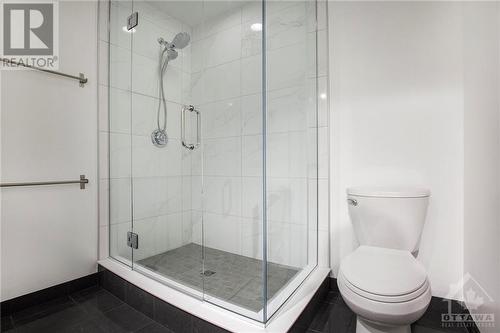 Primary ensuite bathroom has been recenlty renovated and features double vanity sink, glassed in shower and tile flooring - 364 Cooper Street Unit#403, Ottawa, ON - Indoor Photo Showing Bathroom