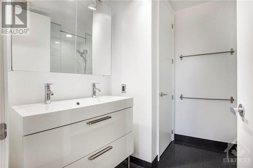 Primary ensuite bathroom has been recenlty renovated and features double vanity sink, glassed in shower and tile flooring - 364 Cooper Street Unit#403, Ottawa, ON - Indoor Photo Showing Bathroom